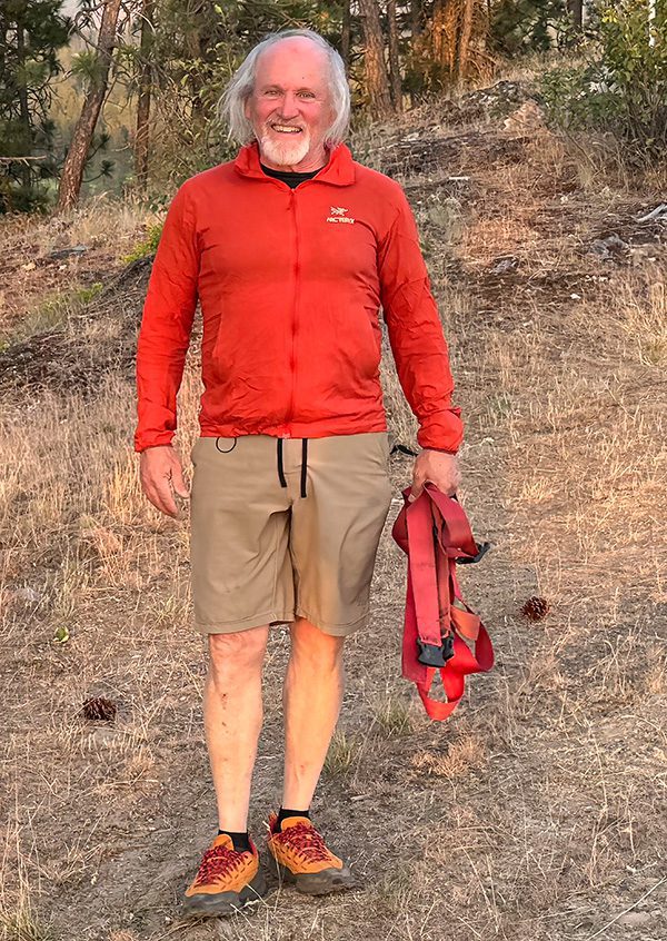 Man in red jacket standing outdoors.